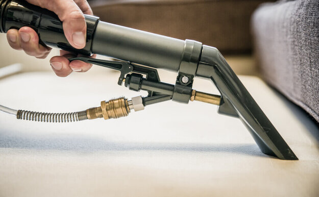 close up of a carpet stain remover vacuum with a trigger for liquid dispense 